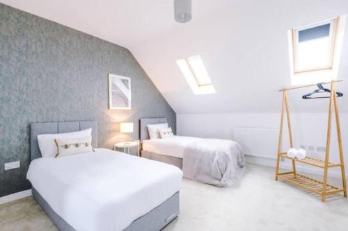 una camera da letto con due letti e due finestre di Spacious 4-Bed Manchester Home a Manchester