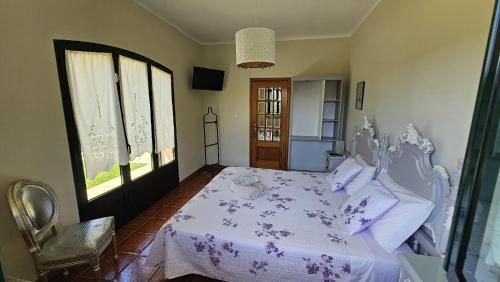 ein Schlafzimmer mit einem weißen Bett mit lila Bettwäsche und Kissen in der Unterkunft Casa Além Rio - quartos para 6 hóspedes em Santo Tirso in Santo Tirso