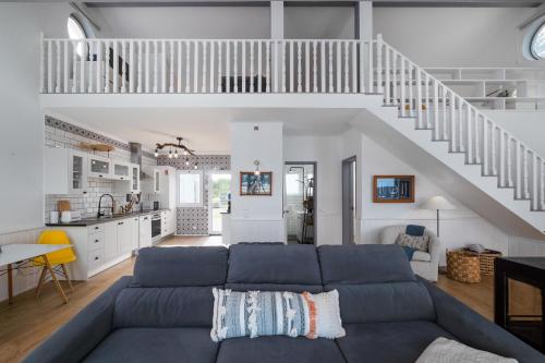 a living room with a blue couch and a staircase at Serenity Villa in Mosteiros
