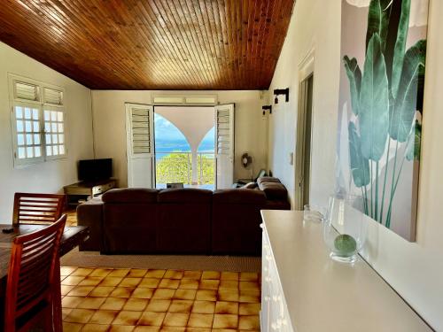 a living room with a couch and a table at Terrasse Panoramique, Calme et Spacieux, Vue sur Mer in Le Lamentin