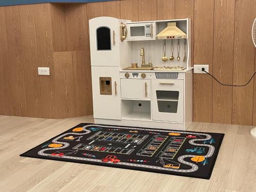 a toy kitchen with a microwave and a rug at 洄游民宿 Migration B&B in Donggang