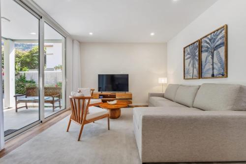 a living room with a couch and a table at Coastal Charm by Homie in Quinta do Almeida