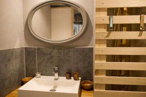 un bagno con un lavandino bianco e uno specchio di Chambre, sauna, piscine à la campagne a Léguillac de Cercles