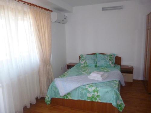 a small bedroom with a bed and a window at Pensiunea Simona in Perişor