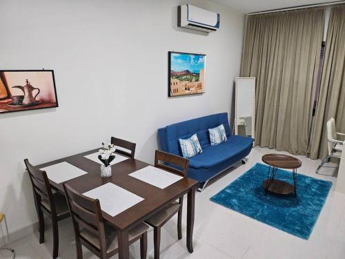 a living room with a table and a blue couch at Best Appartment in Al Khuwair in Bawshar