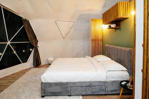 a bedroom with a bed and a large window at Kallias Dome Resort in Sovata