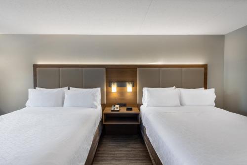 two beds in a hotel room with white sheets at Holiday Inn Express State College at Williamsburg Square by IHG in State College