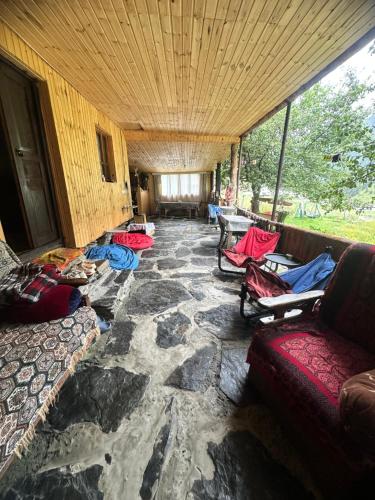 a room with a stone floor with couches and chairs at Pirikiti in Akhmety
