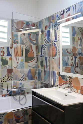a bathroom with a sink and a mirror at Villa Kouleur Kafé in Sainte-Anne