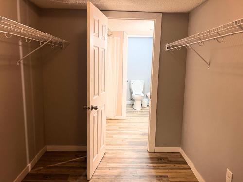 an empty hallway with a toilet in a bathroom at Flowealth Suites - Private Rooms Near West Edmonton Mall in Edmonton