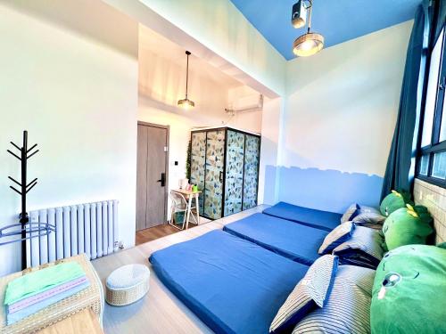 a bedroom with a blue bed and a window at East Coast Coffee Inn in Xi'an