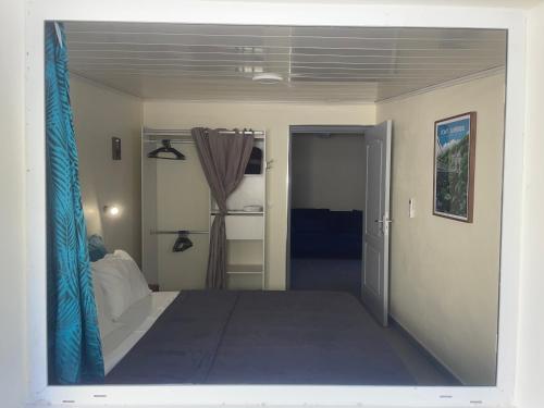 a view of a bedroom with a bed and an open door at El Dorado Ste Rose 3 étoiles in Sainte-Rose