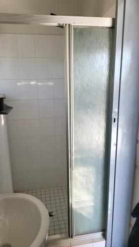 a shower with a glass door next to a sink at The Concept in Centurion