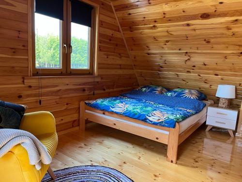 WiżajnyにあるDomek Całorocznyの丸太小屋のベッドのある寝室