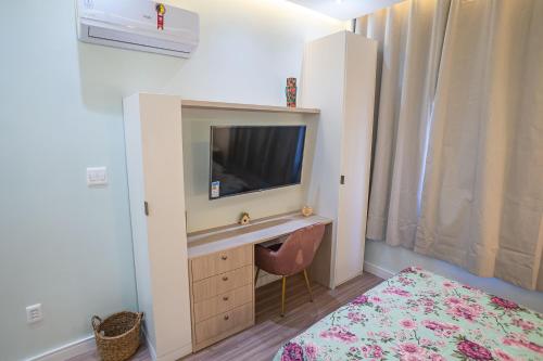 a bedroom with a desk with a television and a bed at Hortênsia Confort Stúdio Rio in Rio de Janeiro