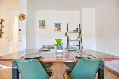 une salle à manger avec une table et des chaises vertes dans l'établissement Le République - Beau duplex avec 2 ch hypercentre, à Marseille