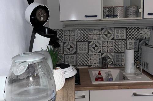 un comptoir de cuisine avec une horloge murale dans l'établissement Quiet T2 near the beach in Villers-sur-Mer, à Villers-sur-Mer