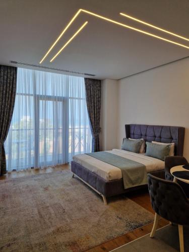 a bedroom with a bed and a large window at Seabreeze Baku Lighthouse seaview apartment studio in Baku