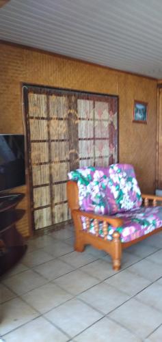 a couch sitting in a living room next to a tv at Maupiti Authentique in Te-Fare-Arii