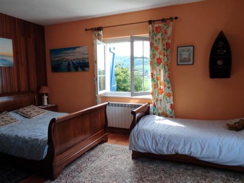 une chambre avec deux lits et une fenêtre dans l'établissement Maison Biziari, à Urrugne