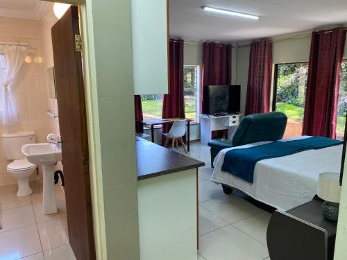 a hotel room with a bed and a bathroom at Palm inn in Rosherville