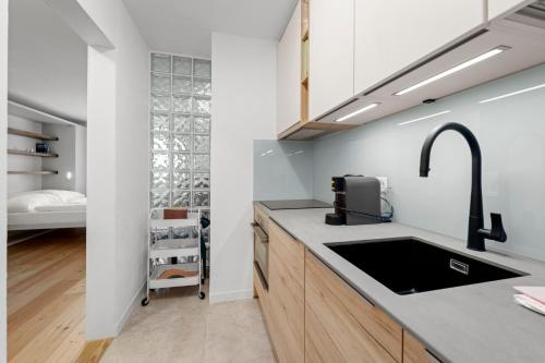 a kitchen with a sink and a bedroom in the background at Abitaziun Tschierv 35 - Celerina in Celerina