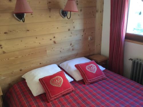 - une chambre avec 2 oreillers rouges sur un lit dans l'établissement Appartement Duplex 3 Chambres pour 6 Personnes avec Balcon à Valloire, 400m des Pistes - FR-1-263-297, à Valloire