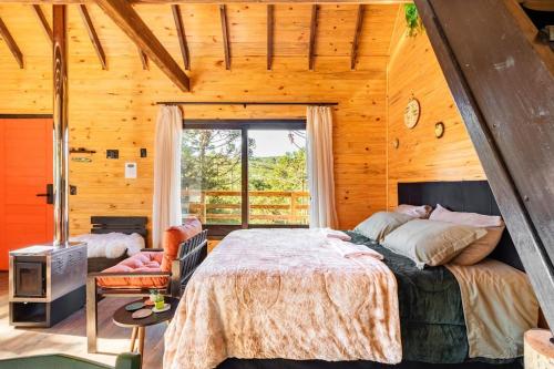 a bedroom with a large bed in a wooden cabin at Vivenda Cambuim do Mundo Novo in Urubici