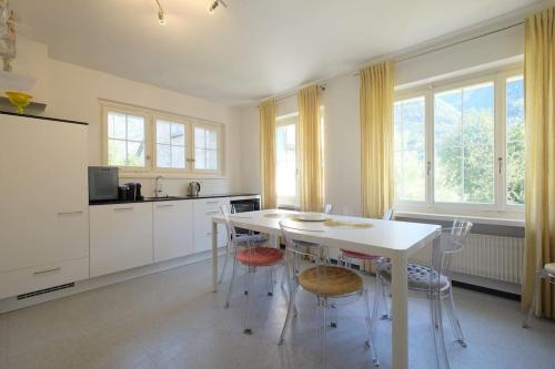 a white kitchen with a white table and chairs at Appartement da Käthy à Grono Val Mesolcina in Grono
