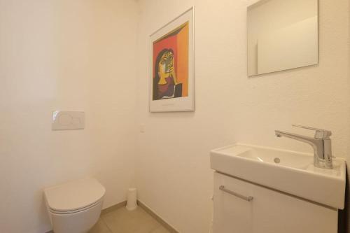 a white bathroom with a toilet and a sink at Appartement da Käthy à Grono Val Mesolcina in Grono
