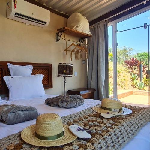 a bedroom with two beds with hats on them at Chalé Girassol - Vila Monte Cunha in Cunha