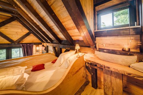 a room with a bed and a sink in a cabin at Les Cabanes de Rensiwez in Mabompré