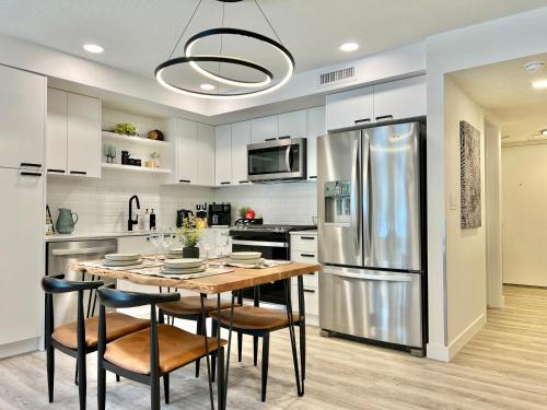 a kitchen with a table with chairs and a refrigerator at Special! New Downtown Mtn View Free Parking 2b&2b in Canmore