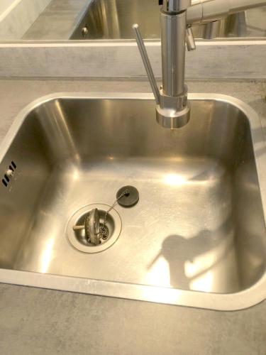 un évier en métal avec une cuillère en métal et une ombre pour les personnes dans l'établissement Séjour Perpignan avec piscine - Petit-déjeuner à la demande - 20 minutes de l'Espagne - Le Palace climatisé, à Perpignan