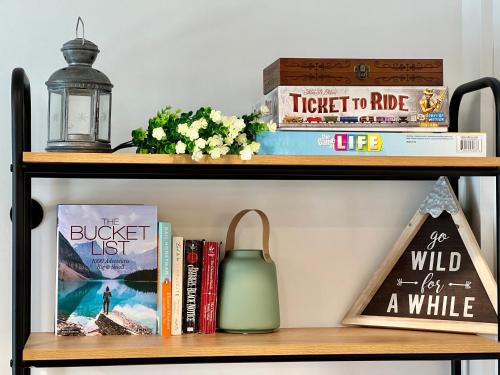 a book shelf with books and a candle at Special! New Downtown Mtn View Free Parking 2b&2b in Canmore