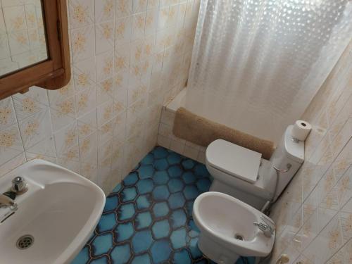 a bathroom with a white toilet and a sink at La casita en la Alcornocosa -Sevilla in Seville