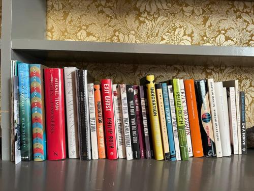 a row of books sitting on a shelf at Historisk villa med klassiske detaljer in Snertingdal