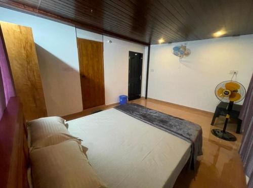 a room with a bed and a fan in it at Tjmaryland villa in Pinangode