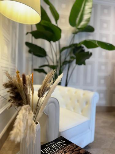 a table with a vase with plants and a chair at Domus De Cinti Boutique Rooms in Tivoli