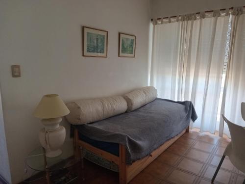 a bedroom with a bed with a blanket and a lamp at Panoramico Playa Grande -Solo Familias in Mar del Plata