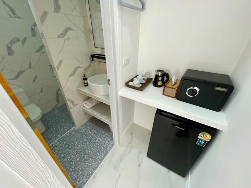 a small bathroom with a toilet and a sink at Pavana Boutique & Kite Bungalows in Thongsala