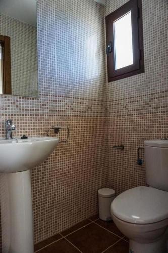 a bathroom with a sink and a toilet and a mirror at El Olmo in Seville