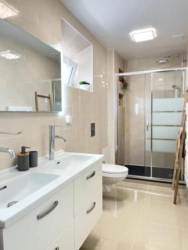 une salle de bain blanche avec un lavabo et des toilettes dans l'établissement Disney famille Cœur de la Ville, à Meaux