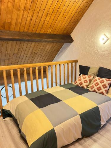 un lit dans une chambre avec un plafond en bois dans l'établissement Disney famille Cœur de la Ville, à Meaux