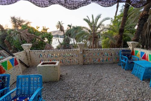 a patio with blue chairs and a fence at Samara Guest House in Aswan