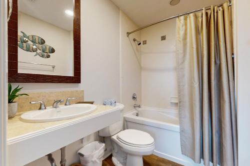 a bathroom with a sink and a toilet and a tub at Luau 7010 in Destin