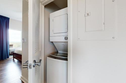 a bathroom with a washer and dryer next to a door at Luau 7010 in Destin