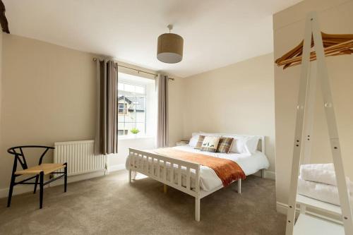 a white bedroom with a bed and a window at OLD BANK HOUSE - Perfect Getaway for Friends & Families in Holker
