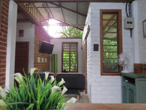 a living room with a couch and some windows at Hogar&Selva, casa vacacional in Tena