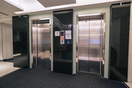 a row of elevator doors in a building at Hotel Puri Taipei Station Branch in Taipei